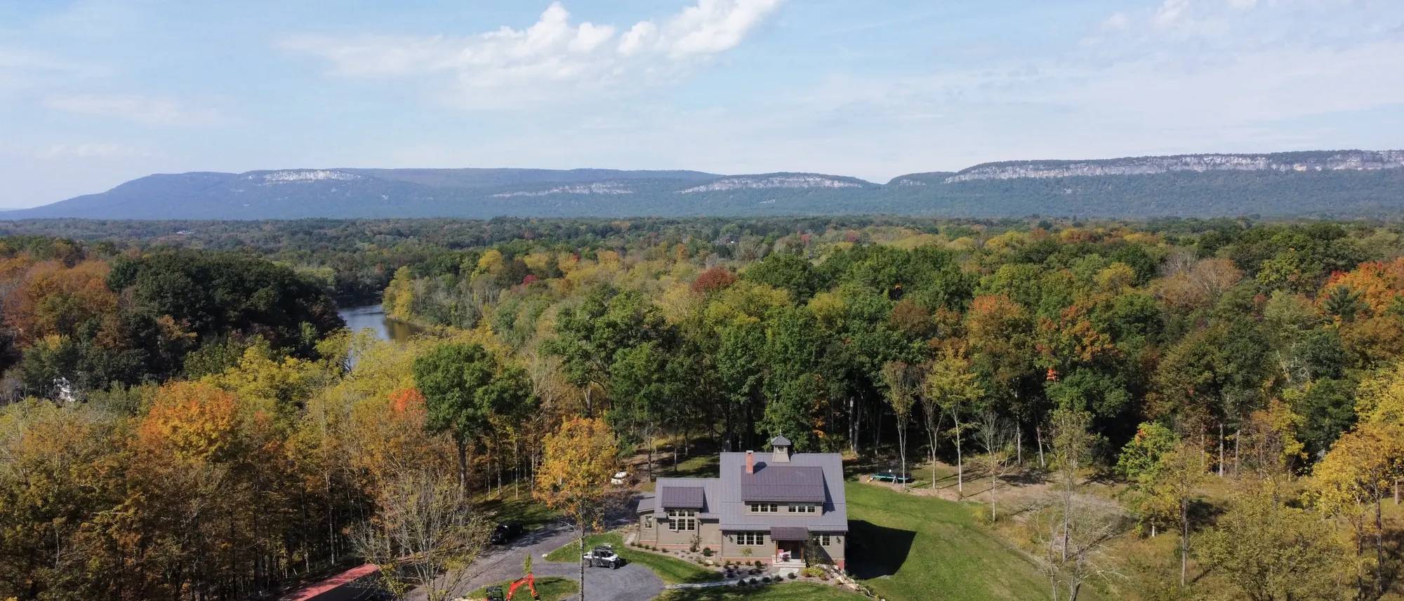 Aerial view of a custom new construction home by Wiley Construction, with the Shawangunk Ridge behind